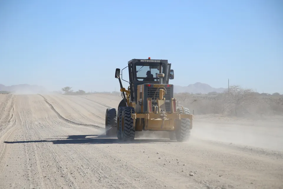 Grader working across a gravel road surface